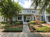 Charming two-story townhouse with inviting landscaping, including green shrubs and trees framing the entrance at 8417 Leeland Archer Blvd, Orlando, FL 32836