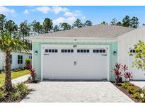 Charming home featuring a spacious white garage door and a beautiful paver driveway at 867 Bama Breeze Dr, Daytona Beach, FL 32124