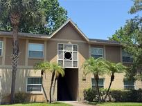 Inviting two-story condo building with manicured lawn and small palm trees at 9926 Turf Way # 8, Orlando, FL 32837