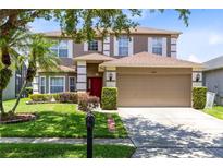 Charming two-story home with a well-manicured lawn and attached two-car garage at 14883 Hartford Run Dr, Orlando, FL 32828