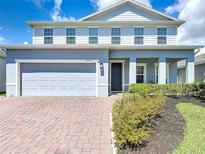 Charming two-story home with a brick driveway, attached two-car garage, and manicured landscaping at 2943 Slough Creek Dr, Kissimmee, FL 34744