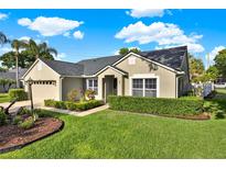 Charming single-story home featuring a manicured lawn, lush landscaping, and inviting curb appeal on a sunny day at 3499 Woodley Park Pl, Oviedo, FL 32765