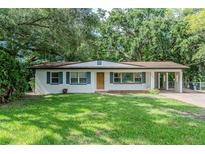 Charming single-story home with a well-maintained lawn, blue shutters, and a convenient carport at 409 E Gulley Ave, Oakland, FL 34760