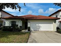 Charming single Gathering home featuring a red tile roof, two-car garage, and manicured lawn at 446 Summer Place Loop, Clermont, FL 34714