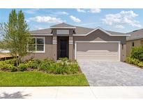 Charming single-Gathering home with manicured lawn and a two-car garage on a sunny day at 499 Silver Palm Dr, Haines City, FL 33844