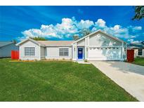 Charming single-story home with a well-manicured lawn and a bright blue front door at 5037 Water Wheel Ct, Ocoee, FL 34761