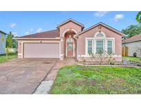 Charming single-story home with a well-manicured lawn and a two-car garage on a sunny day at 5273 Sunset Canyon Dr, Kissimmee, FL 34758