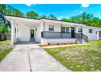 Charming one-story home featuring a covered porch, black railings, and well-maintained landscaping at 5513 Riordan Way, Orlando, FL 32808