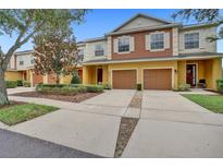 Inviting townhome with a two-car garage and well-maintained landscaping and a long driveway at 707 N Marotta Loop, Ocoee, FL 34761