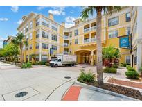 Beautiful yellow condo building with palm trees and well-maintained landscaping at Park North at Cheney Place at 860 N Orange Ave # 323, Orlando, FL 32801