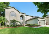 Charming home featuring lush landscaping, a well-manicured lawn, and a traditional stucco facade at 1161 Coastal Cir, Ocoee, FL 34761