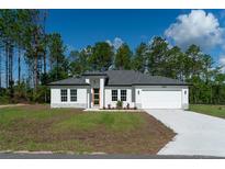 Charming one-story home featuring a well-manicured lawn and inviting front entrance at 13420 Sw 77Th Ave, Ocala, FL 34473
