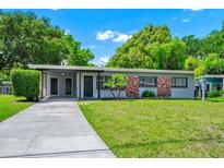Charming single-story home with a well-manicured lawn and brick accents at 1408 Watts Ave, Orlando, FL 32809