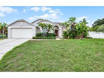 Charming single-story home with a well-manicured lawn and tropical landscaping at 145 Henue Ct, Davenport, FL 33896