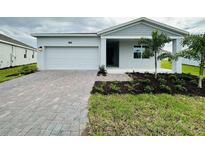 Charming single-story home with a brick driveway, well-maintained lawn, and a one car garage at 1590 Contentment Loop, Kissimmee, FL 34744