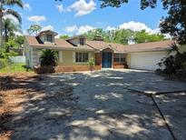 Charming single-story home with dormer windows, blue entry door, and a spacious driveway at 1695 E Horatio Ave, Maitland, FL 32751