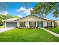 Charming single-story home with a well-manicured lawn, blue front door and attached garage at 2095 Curry Ln, Orlando, FL 32812