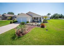 Charming single-story home with a well-manicured lawn, tasteful landscaping, and a cozy front porch at 2167 Kerwood Loop, The Villages, FL 32162