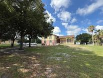 Inviting two-story home featuring a covered porch, large front yard, and plenty of parking at 2500 Derby Dr, Kissimmee, FL 34744