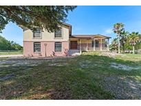 Charming two-story home with a brick and stucco exterior and a welcoming front porch at 2500 Derby Dr, Kissimmee, FL 34744