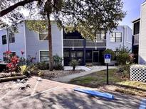 Two-story condo with blue siding, balcony, and a designated handicap parking spot at 3621 Atrium Dr # U-4, Orlando, FL 32822