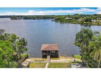Stunning lake view featuring a private boat dock with lift and covered seating area surrounded by lush greenery at 3788 N Econlockhatchee Trl, Orlando, FL 32817