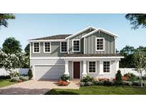 Charming two-story home features a manicured lawn, attached garage, and inviting front porch at 4624 Laurel Site Loop, Apopka, FL 32712