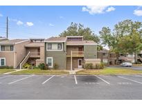 Inviting exterior view of a two-story condo showcasing green facade, wooden stairs and well-maintained landscape at 5071 Eaglesmere Dr # C01, Orlando, FL 32819