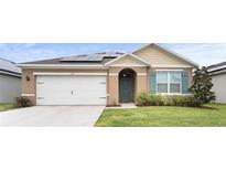 Charming single-story home featuring a two-car garage and solar panels for energy efficiency at 5367 Douglas Fir Dr, St Cloud, FL 34771
