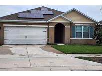 Charming single Gathering home featuring solar panels, attached two car garage, and tidy lawn at 5367 Douglas Fir Dr, St Cloud, FL 34771