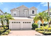 Charming two-story home features a two-car garage and mature landscaping, including palm trees at 7710 Linkside Loop, Reunion, FL 34747