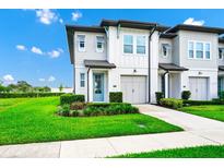 Charming two-story home features a blue front door, a two-car garage, and well-manicured landscaping at 809 Benoi Dr, Davenport, FL 33896