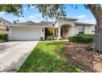 Charming one-story home with a well-manicured lawn, a two-car garage and an arched entryway at 821 Shallow Brook Ave, Winter Springs, FL 32708