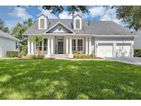 Charming home boasts a manicured lawn, columns, and a two-car garage at 8430 Woburn Ct, Windermere, FL 34786