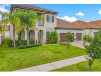 Charming home featuring a well-manicured lawn, a three-car garage, and tropical landscaping at 8491 Pippen Dr, Orlando, FL 32836