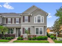 Beautiful two-story home featuring a well-maintained lawn, mulch beds, and brick paver sidewalk at 8500 Iron Mountain Trl, Windermere, FL 34786