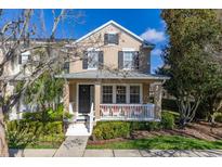Charming two-story home featuring a cozy front porch with white railings and lush landscaping at 9141 Camden Gardens St, Orlando, FL 32827