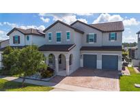 Charming two-story home with a brick driveway, archway covered porch, and a two-car garage at 9845 Emerald Berry Dr, Winter Garden, FL 34787