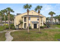 Inviting yellow two-story building with tropical landscaping and classic exterior stairway at 1031 S Hiawassee Rd # 2517, Orlando, FL 32835