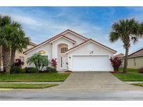 Charming single-Gathering home featuring a red tile roof, well-manicured lawn, and a two-car garage at 117 Rosso Dr, Davenport, FL 33837
