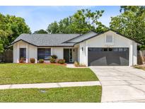 Charming single-story home with a well-maintained lawn, gray roof, and an attached two-car garage at 12929 Louisiana Woods Ct, Orlando, FL 32824