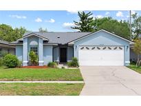 Charming one-story home with a well-manicured lawn and attached two-car garage at 12952 Downstream Cir, Orlando, FL 32828