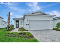 Charming single-story home features a well-manicured lawn, paved driveway, and attached two-car garage at 1459 Santorini Way, Tavares, FL 32778