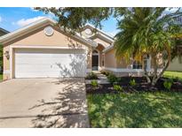 Charming single-story home featuring a two-car garage and lush landscaping at 3078 Mandolin Dr, Kissimmee, FL 34744