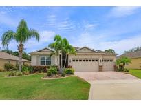 Charming single-story home with a three-car garage, a well-manicured lawn and mature tropical landscaping at 3755 Sanibel St, Clermont, FL 34711