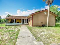 Charming single-story home with a cozy porch and a well-maintained lawn under a sunny blue sky at 4432 Freedom Rd, Kissimmee, FL 34746