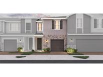 New townhome boasts gray brick facade, garage, lush landscaping and sidewalks for pedestrian-friendly living at 560 Southern Edge Way, Sanford, FL 32771