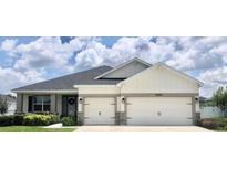Charming one-story home featuring a three-car garage, landscaped yard, and inviting entrance at 6686 Treymont Dr, Lakeland, FL 33813