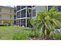 Landscaped condominium building with large grassy common area and tropical foliage at 717 S Beach St # 205C, Daytona Beach, FL 32114