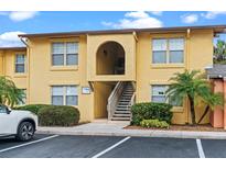 Inviting yellow condo building with well-kept landscaping and convenient parking at 758 E Michigan St # 208, Orlando, FL 32806